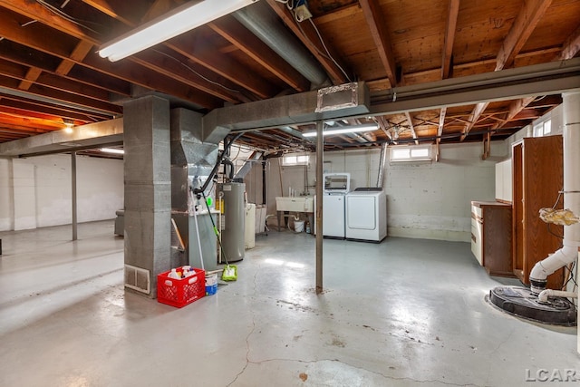 basement with water heater, separate washer and dryer, and sink