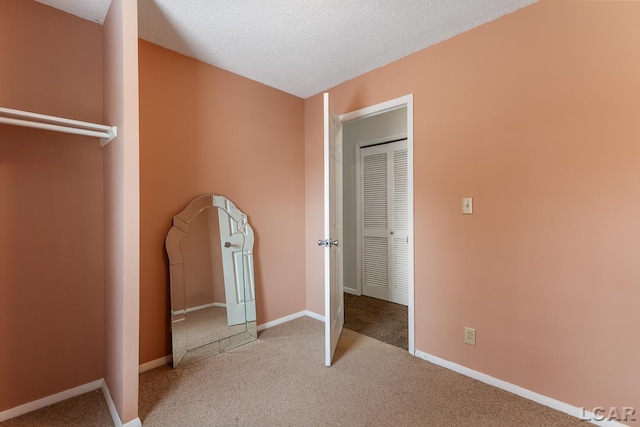 unfurnished bedroom with light carpet and a textured ceiling