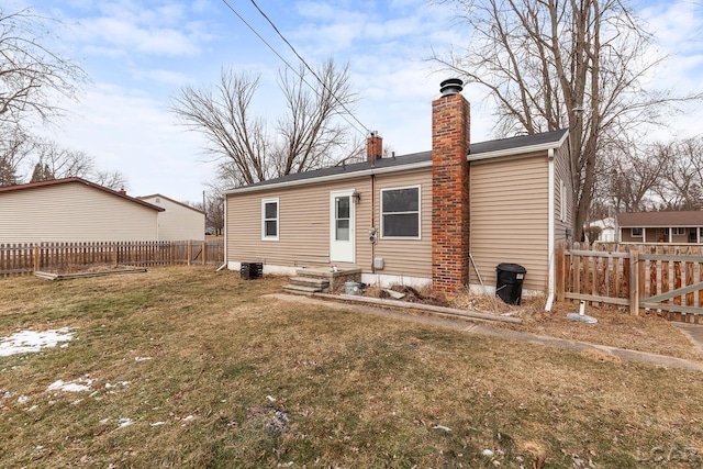 rear view of property with central AC and a lawn