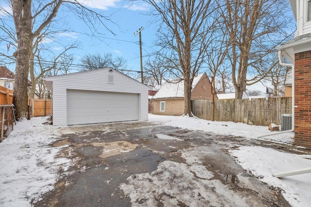 snow covered garage featuring central AC unit