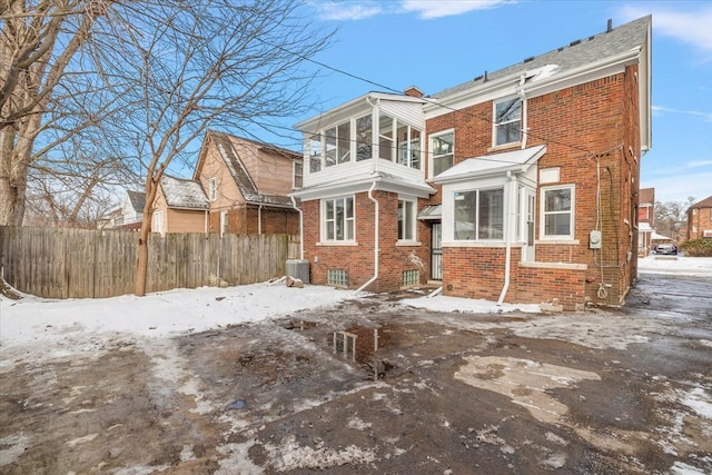 snow covered house with central air condition unit