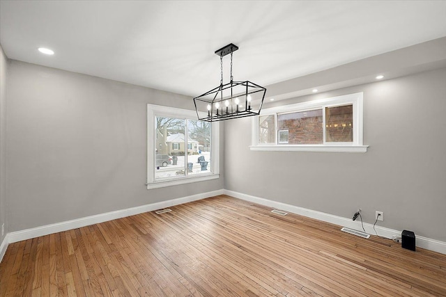 unfurnished dining area featuring wood-type flooring and a healthy amount of sunlight