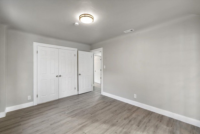 unfurnished bedroom featuring light hardwood / wood-style flooring and a closet