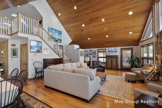 living room with wood ceiling, a healthy amount of sunlight, and high vaulted ceiling