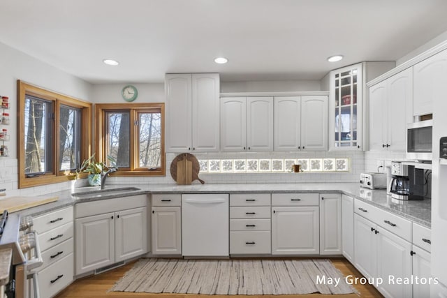 kitchen featuring backsplash, appliances with stainless steel finishes, sink, and white cabinets