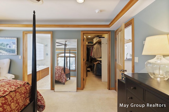 bedroom featuring crown molding, a spacious closet, and light carpet