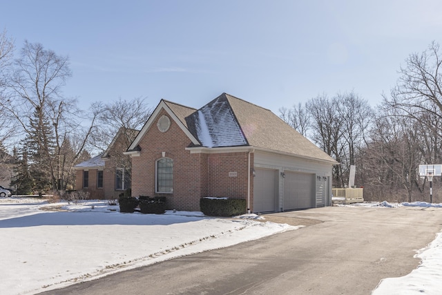 view of snow covered exterior featuring a garage