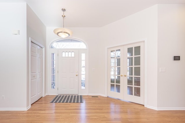 foyer entrance featuring french doors, light hardwood / wood-style flooring, and a wealth of natural light