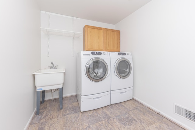 laundry room featuring cabinets and washing machine and clothes dryer