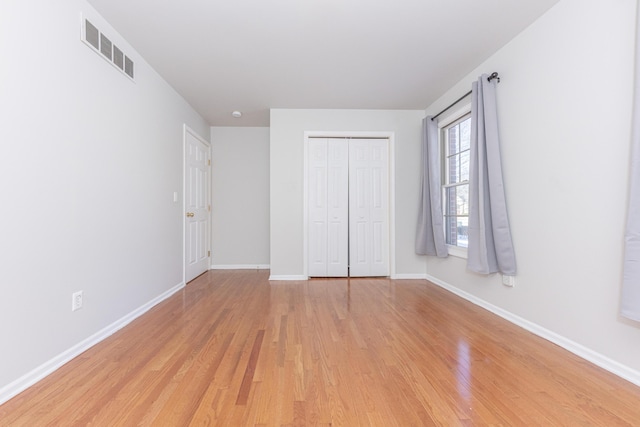 unfurnished bedroom with a closet and light hardwood / wood-style flooring