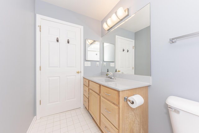 bathroom featuring vanity, tile patterned floors, and toilet