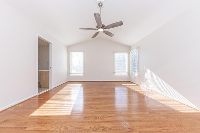 empty room with ceiling fan, lofted ceiling, and light wood-type flooring