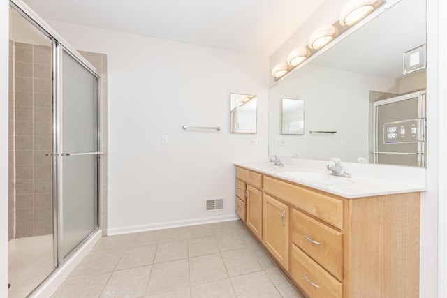 bathroom featuring tile patterned flooring, vanity, and a shower with shower door