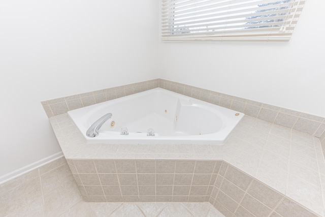 bathroom with a relaxing tiled tub and tile patterned floors