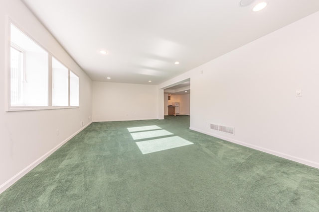 spare room with dark colored carpet