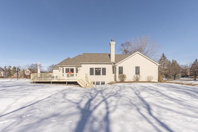 snow covered rear of property featuring a deck