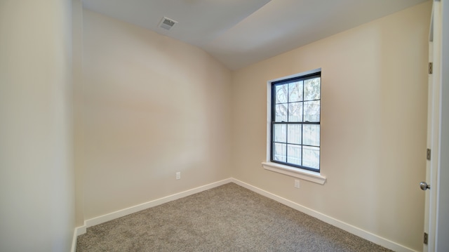 carpeted empty room with lofted ceiling