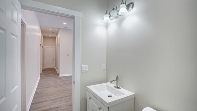 bathroom featuring vanity, wood-type flooring, and a notable chandelier