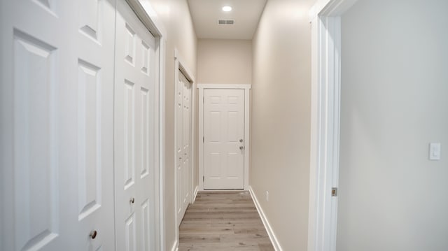 corridor with light hardwood / wood-style floors