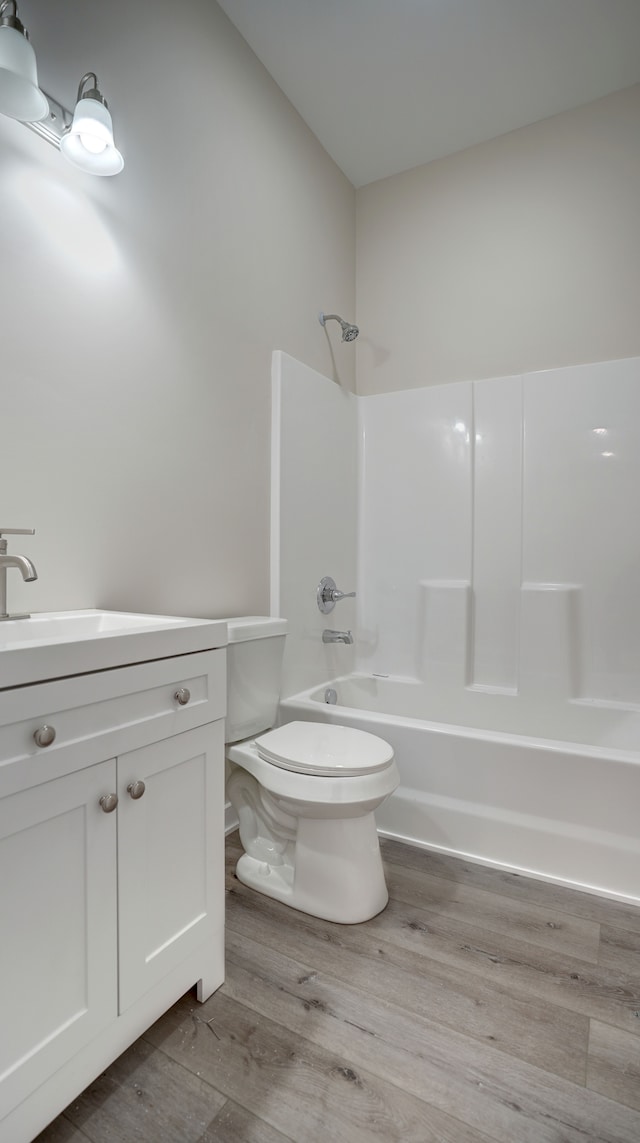 full bathroom with bathtub / shower combination, wood-type flooring, toilet, and vanity