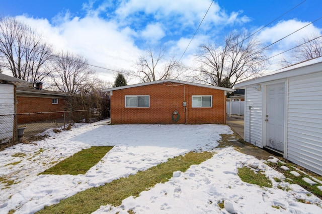 view of snow covered rear of property