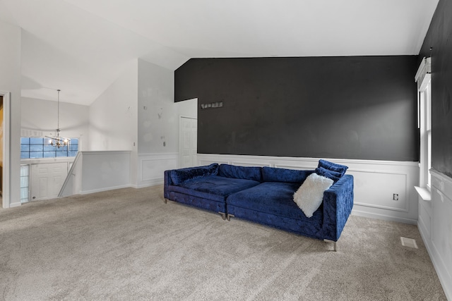 carpeted living room with an inviting chandelier and lofted ceiling