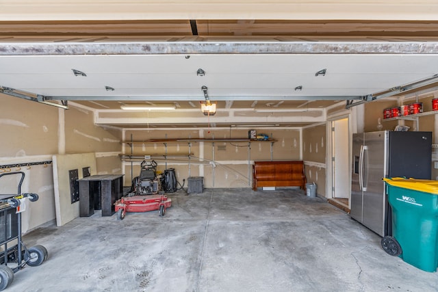 garage featuring a garage door opener and stainless steel refrigerator with ice dispenser