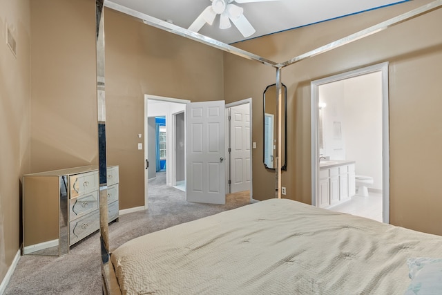 bedroom featuring ceiling fan, light colored carpet, and ensuite bathroom