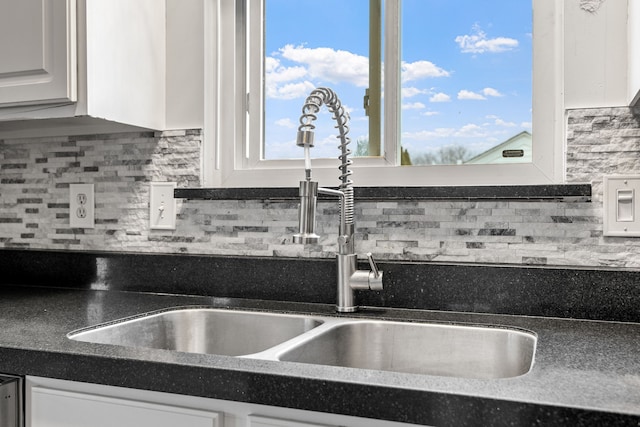 kitchen with white cabinetry, sink, and tasteful backsplash