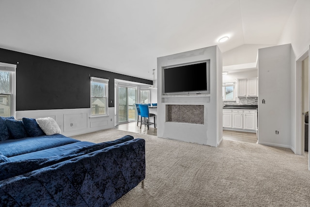 carpeted living room featuring vaulted ceiling