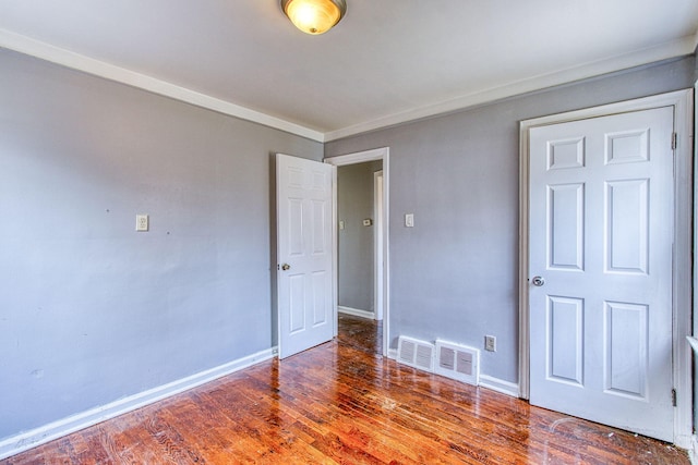 empty room featuring ornamental molding and dark hardwood / wood-style floors