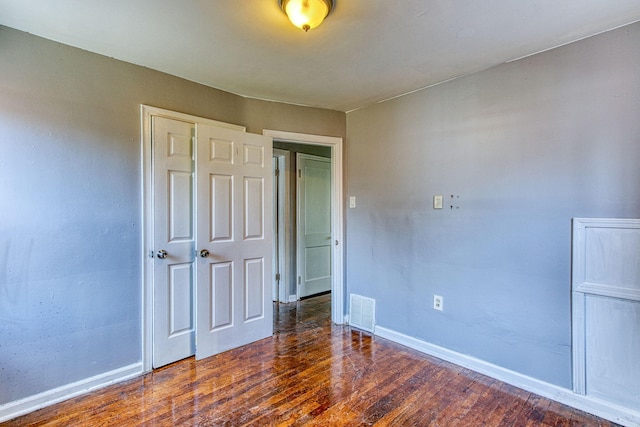 unfurnished bedroom featuring dark hardwood / wood-style flooring