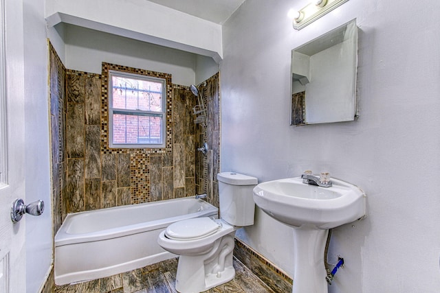 bathroom with tiled shower / bath combo, hardwood / wood-style flooring, and toilet