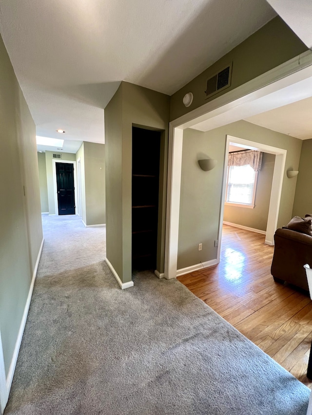 hallway featuring light colored carpet