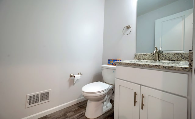 bathroom with vanity, wood-type flooring, and toilet