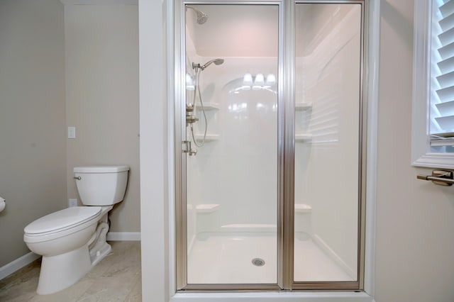 bathroom featuring toilet and an enclosed shower