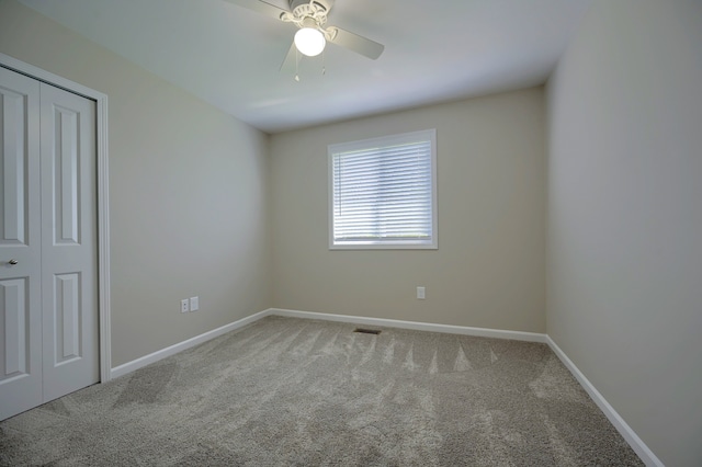 unfurnished bedroom with carpet floors, a closet, and ceiling fan