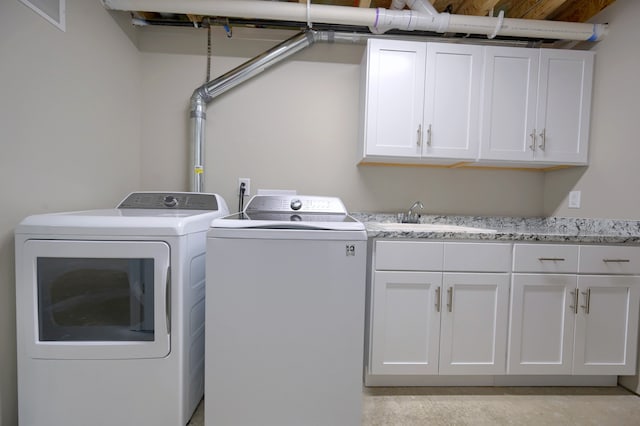 laundry room featuring sink, washer and clothes dryer, and cabinets