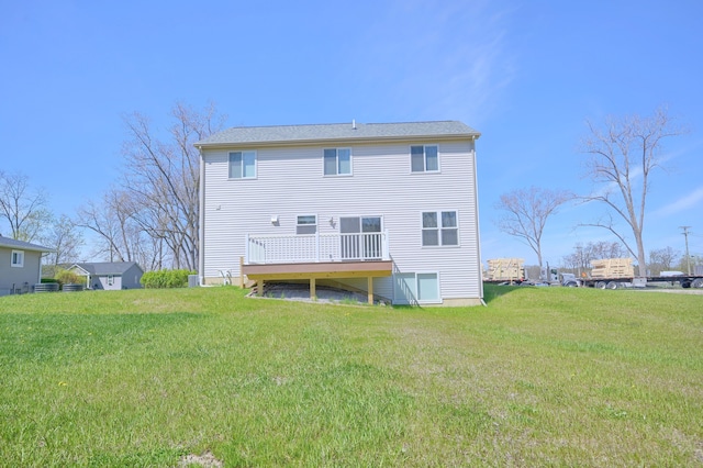 rear view of house with a wooden deck and a yard