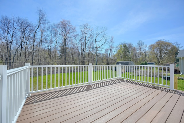 deck featuring a shed and a lawn