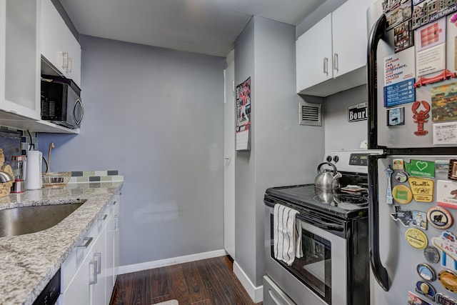 kitchen featuring dark wood-type flooring, stainless steel range with electric stovetop, white cabinetry, fridge, and light stone counters