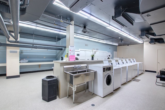 clothes washing area with separate washer and dryer and sink