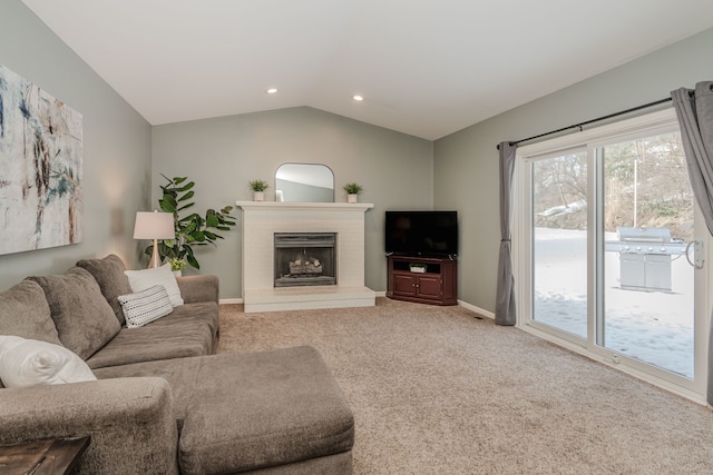 carpeted living room featuring a fireplace and lofted ceiling