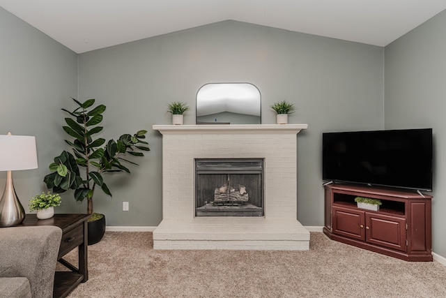 living room featuring a brick fireplace, lofted ceiling, and light colored carpet