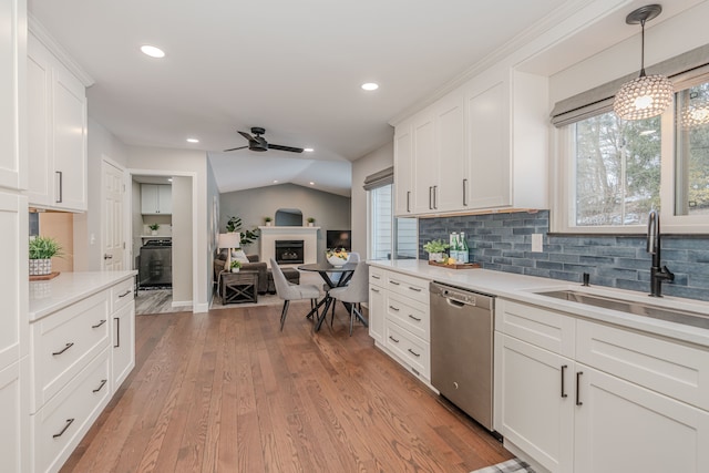 kitchen featuring sink, dishwasher, white cabinetry, and light hardwood / wood-style floors