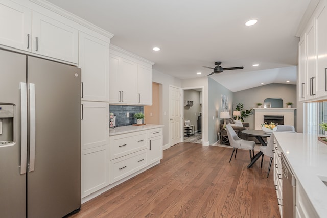 kitchen with white cabinetry, backsplash, appliances with stainless steel finishes, and dark hardwood / wood-style flooring