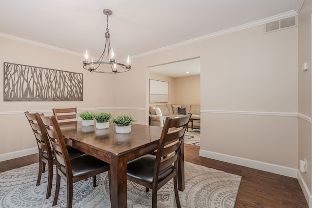 dining space with dark wood-type flooring, crown molding, and a notable chandelier