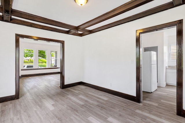 empty room with coffered ceiling, beam ceiling, and light hardwood / wood-style flooring