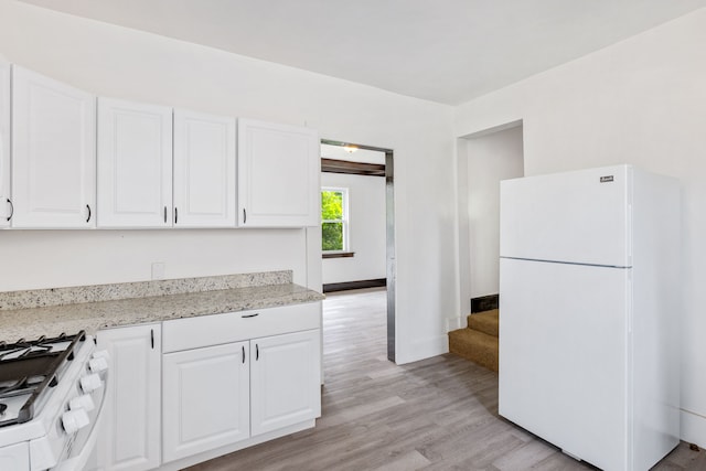 kitchen with white cabinetry, white appliances, light stone counters, and light wood-type flooring