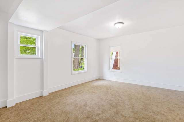 carpeted spare room featuring a healthy amount of sunlight